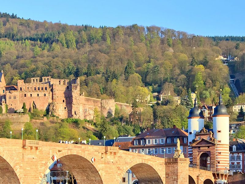 Die Alte Brücke in Heidelberg mit dem Brückentor, dahinter das Schloss am Hang